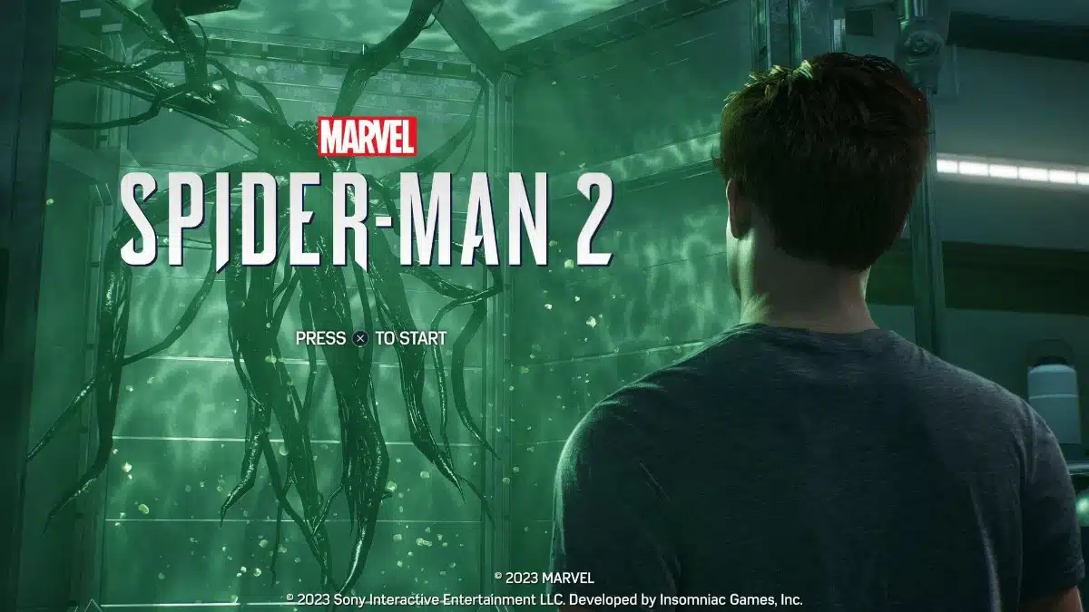 Marvel’s Spider-Man 2 title screen showing a symbiote containment chamber illuminated by green laboratory lighting