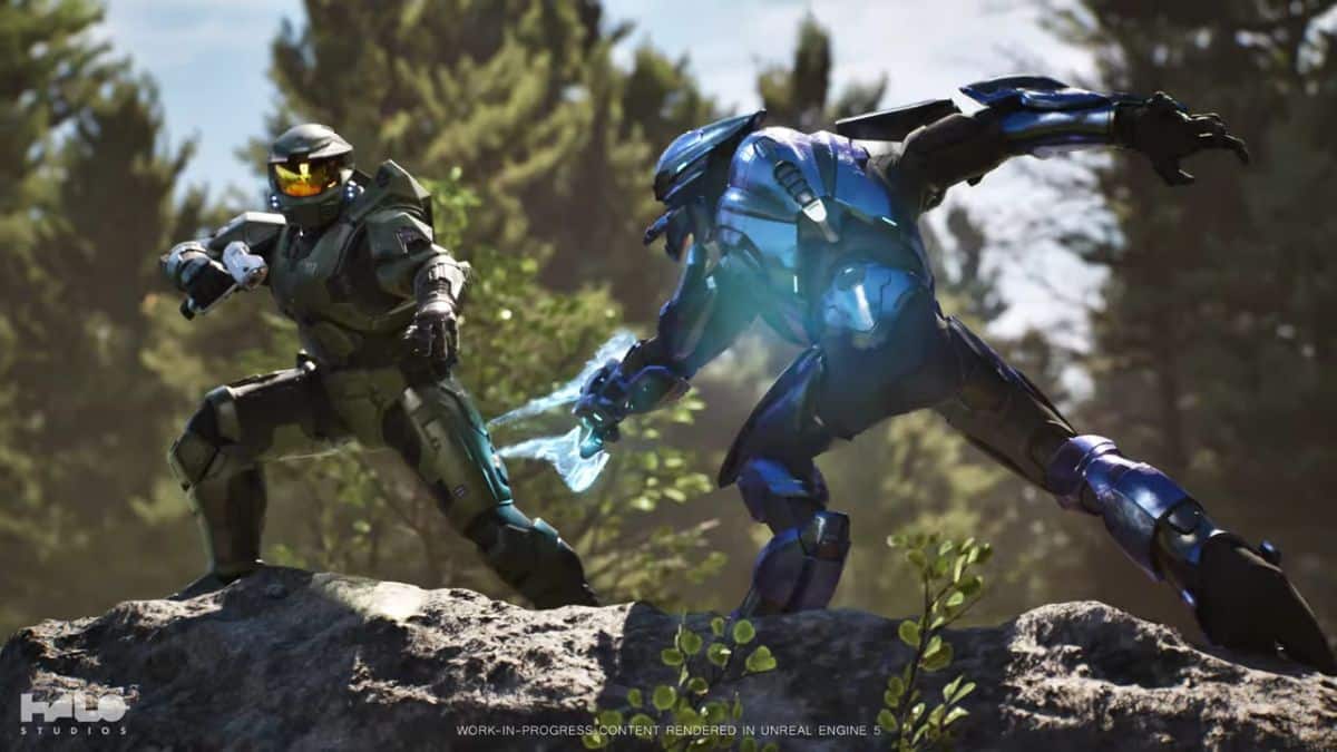 A Master Chief character in green armour confronts a blue alien warrior amidst a forest setting, showcasing an intense battle scene.