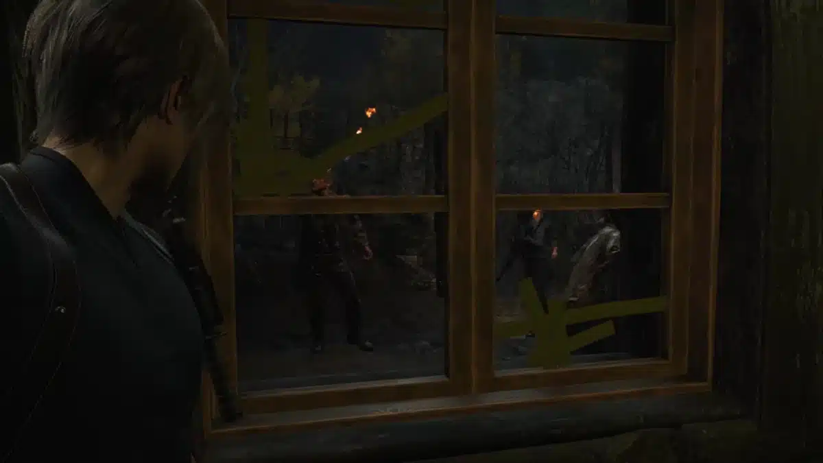 Leon S Kennedy looking out a taped window at three figures with torches in a dark, wooded area.