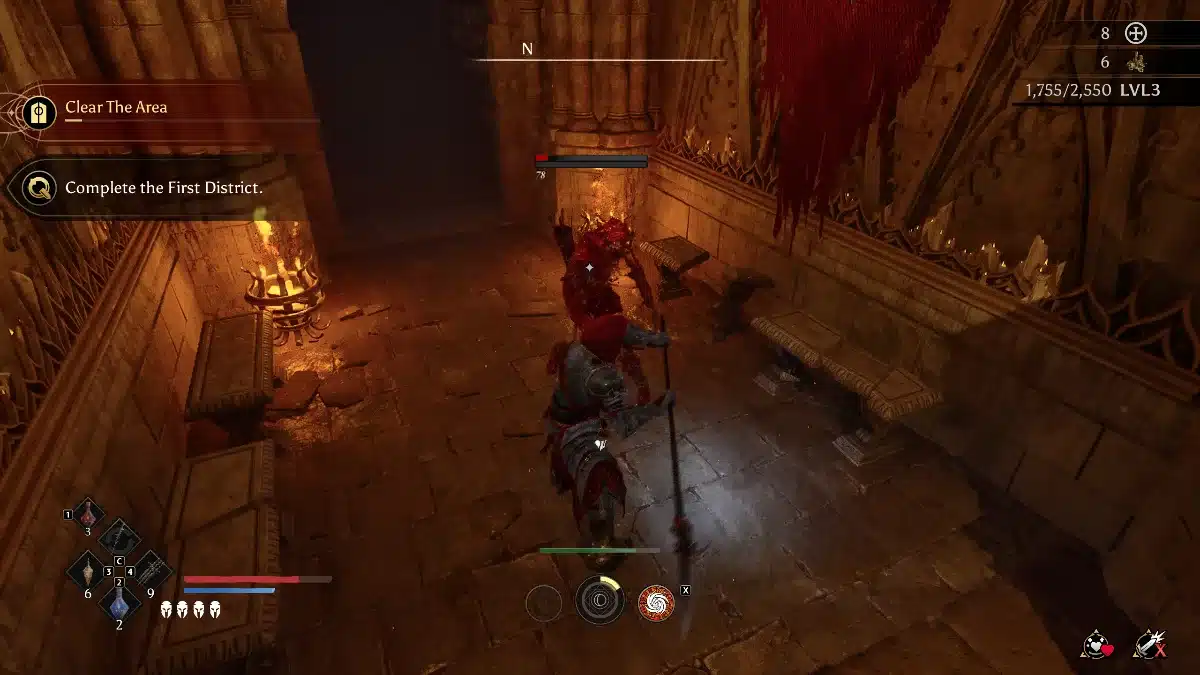 A player character in dark armor with red accents fights a monstrous red enemy with a spear in a dimly lit stone chamber with gothic architecture.