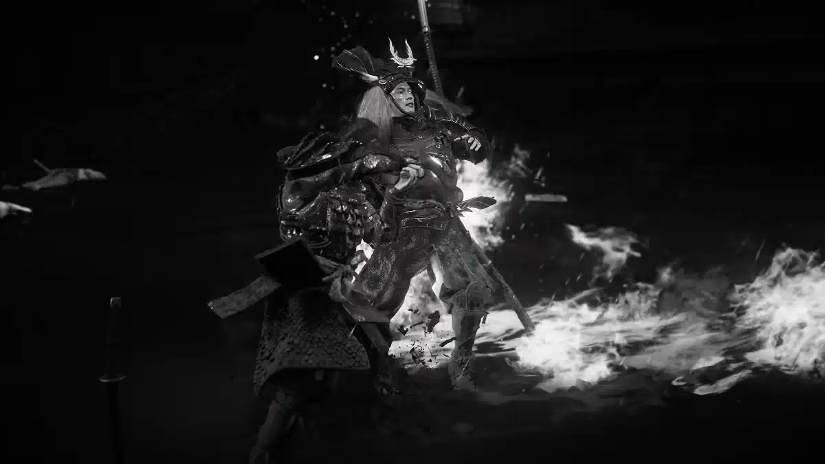 A dramatic, black and white scene depicts two samurai warriors locked in combat amidst flames and smoke, with one warrior in elaborate armor wielding a sword against an opponent.