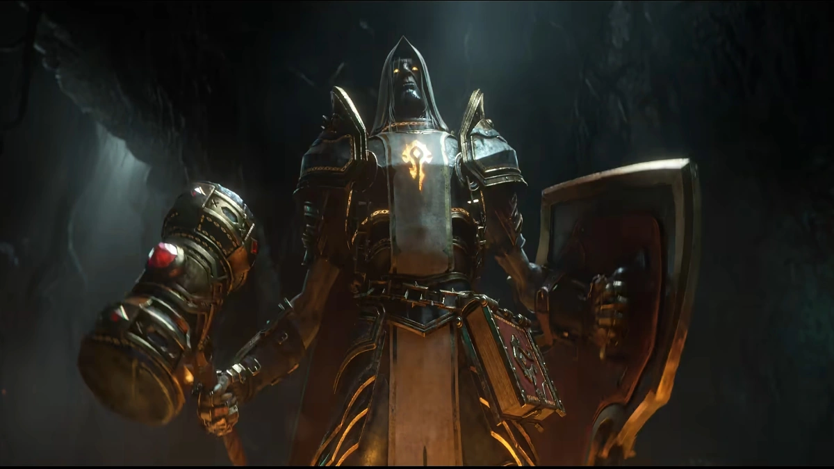 A grim, armored figure wearing a hooded cowl and glowing yellow eyes, holding a large ornate hammer in its right hand and a shield in its left, stands in a dark cavern. A glowing golden insignia, resembling the Horde symbol from World of Warcraft, is visible on its chest.