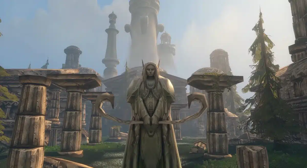 Stone statue of an elf with pointed ears holding a bow, situated in a courtyard with crumbling ancient architecture and tall trees under a hazy sky.