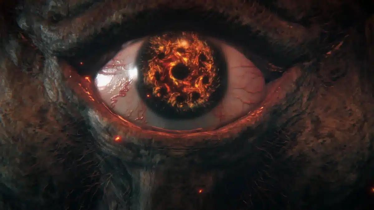 Extreme close-up of a monstrous eye with a fiery, swirling iris and bloodshot sclera, surrounded by dark, textured skin and glowing embers.
