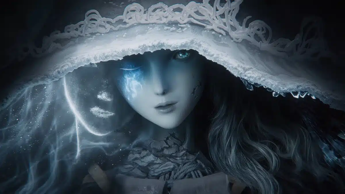 A close-up of a pale-skinned female character with glowing blue patterns on her face and one bright blue eye, wearing a white hooded cloak with intricate detailing.