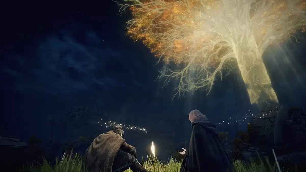 Two figures sit in a grassy field at night, looking up at a colossal, luminous tree with golden autumn leaves. Rays of light stream down from the tree, illuminating the scene. In the distance, a settlement glows with small lights under a dark, starry sky.