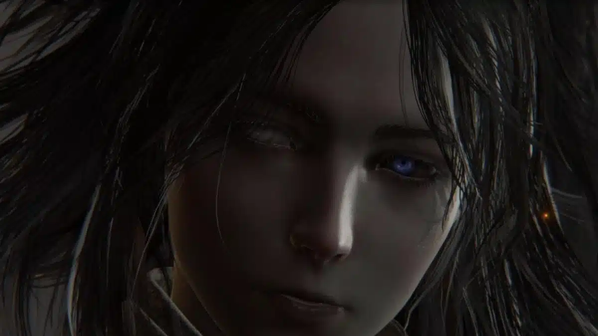 Close-up of a pale-faced figure with dark, messy hair. One eye is a striking electric blue, while the other is white and vacant.