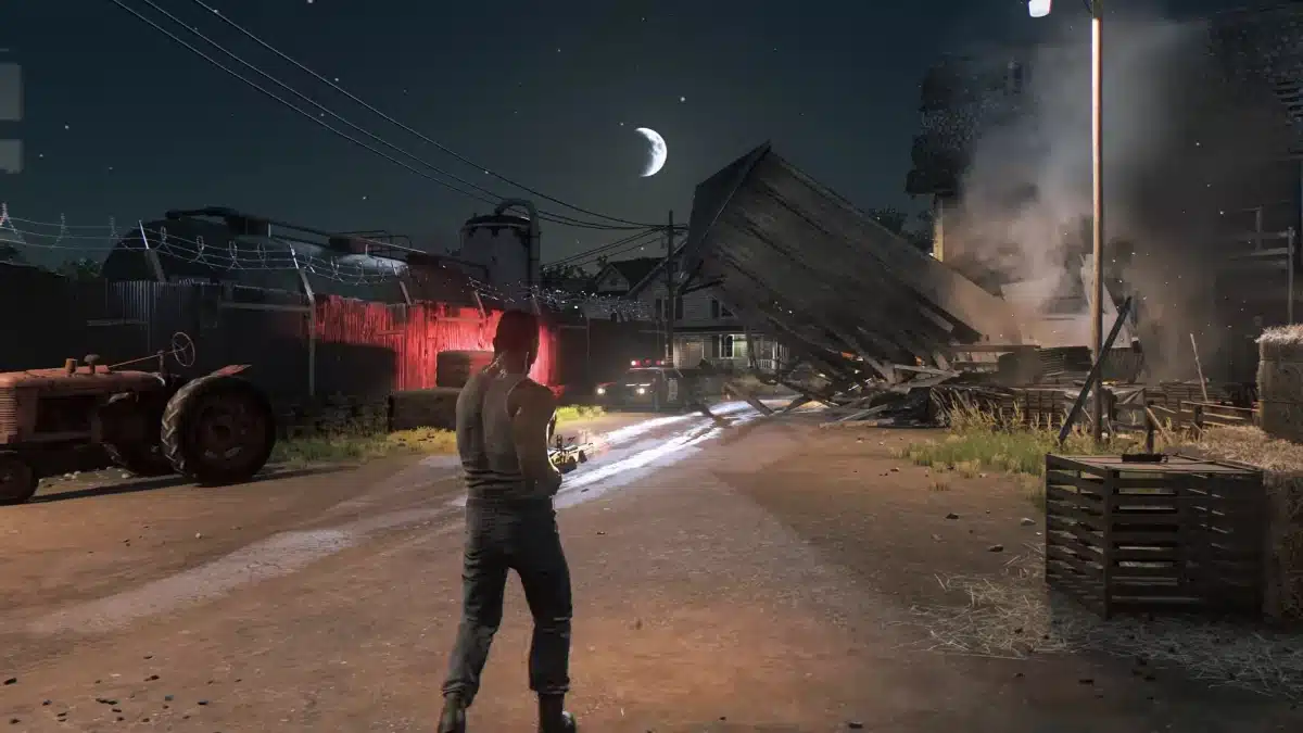 Lincoln Clay stands on a rural road as a barn collapses in Mafia III: Definitive Edition.